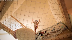 A hammock suspended from a net structure, with a patterned cushion and a wooden beam nearby. - Star&Moon Homestay (Ji'an)
