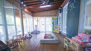 A wooden-floored room with large windows, a chalkboard, and children's play area. - Star&Moon Homestay (Ji'an)