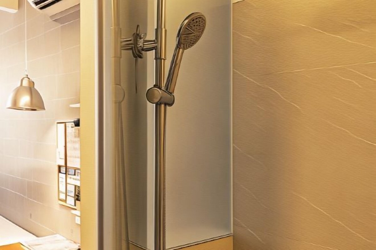 A modern bathroom with a shower, a towel rack, and a pendant light.