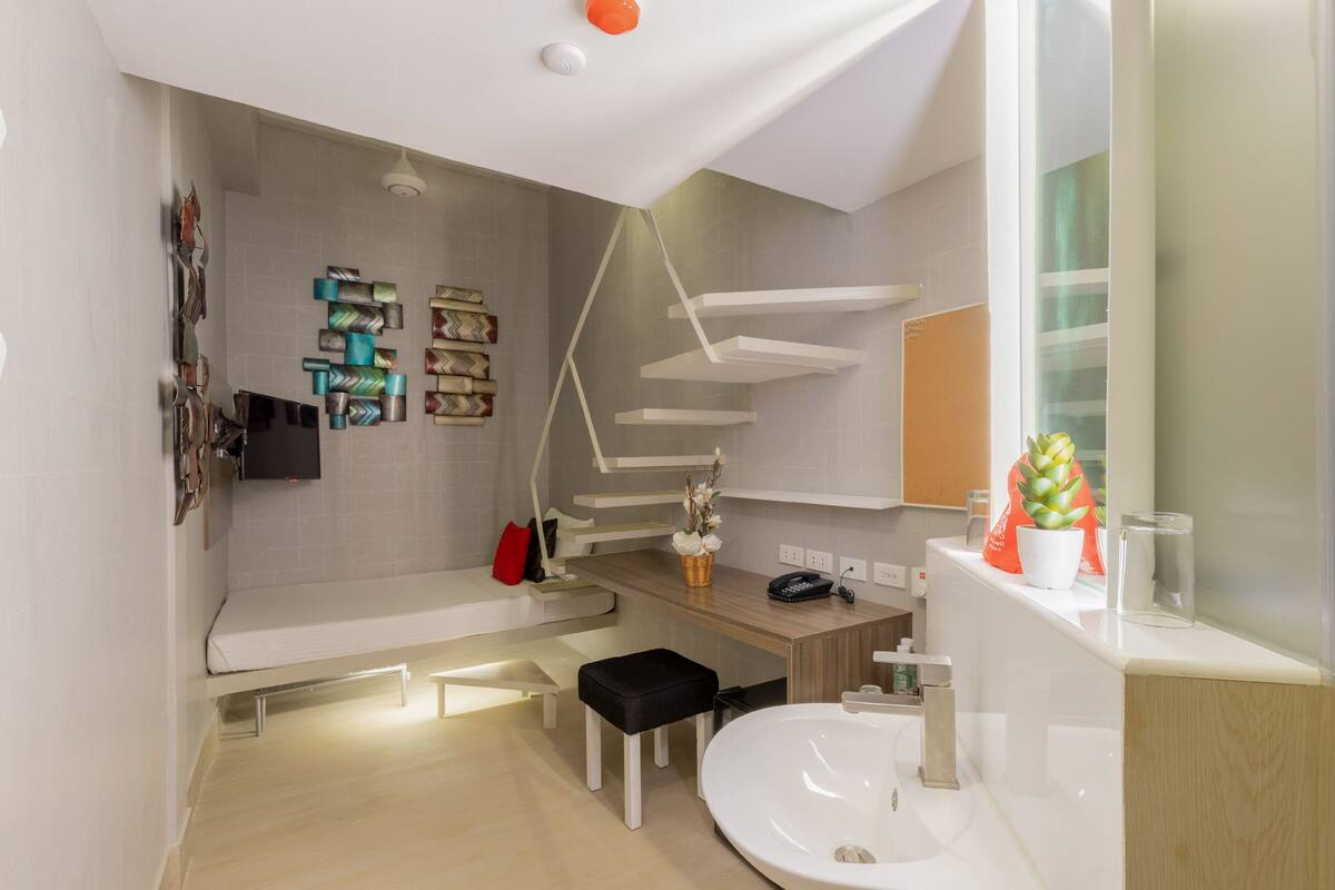 A modern bathroom with a built-in bench, a sink, and a mirror.