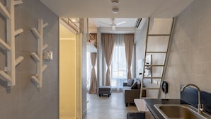 A modern kitchen with a built-in oven, a stainless steel sink, and a ladder for storage. - Selah Pods Hotel Manila (Pasay)