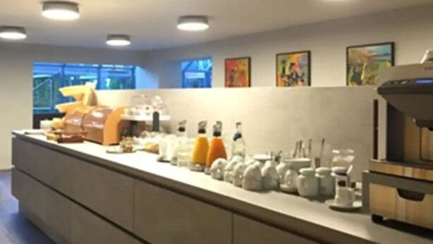 Une cuisine moderne dotée d’un long comptoir, de divers appareils électroménagers et d’armoires de rangement.