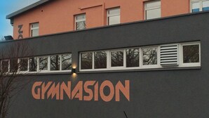 Un bâtiment dont la façade porte en grand le mot « GYMNASION ».