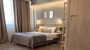 Un dormitorio moderno con cama, armario de madera y sofá.