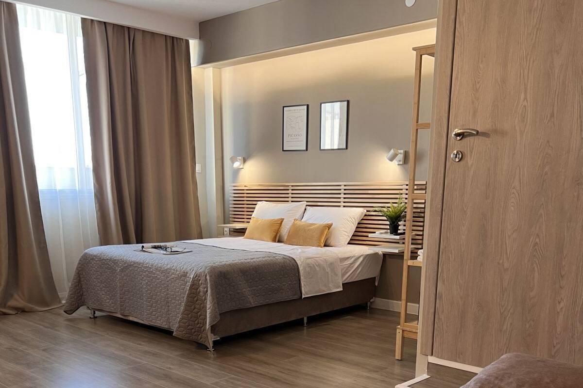 Un dormitorio moderno con cama, armario de madera y sofá.