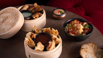 A table with food items including dumplings, a bowl of rice with shrimp, and bread.