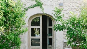 A stone building with a central arched doorway, a small window above, and a stone pathway leading to the entrance. - B&B Barone Gambadoro (Monte Sant'Angelo)
