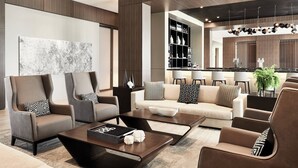 A modern living room with a sofa set, coffee table, and a large abstract painting on the wall. - AC Hotel by Marriott Huntsville Downtown (Huntsville)