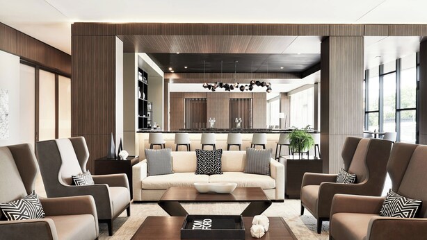 A modern living room with a sofa, armchairs, and a coffee table. - AC Hotel by Marriott Huntsville Downtown (Huntsville)
