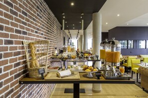 Een ontbijtbuffet met diverse gerechten en een koffiehoek.