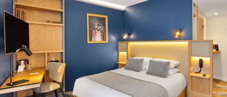 A modern bedroom with a large bed, bedside tables, a desk, and a bookshelf.