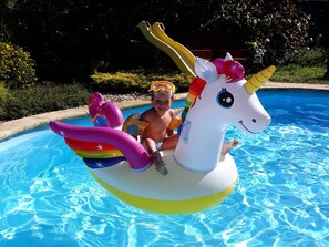 Un niño sobre un flotador con forma de unicornio en una piscina.