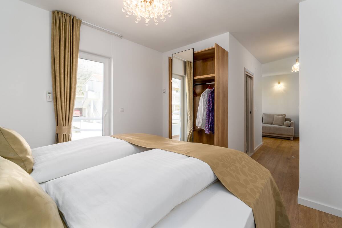 Une chambre avec deux lits, une armoire et une vue sur l’espace de vie.