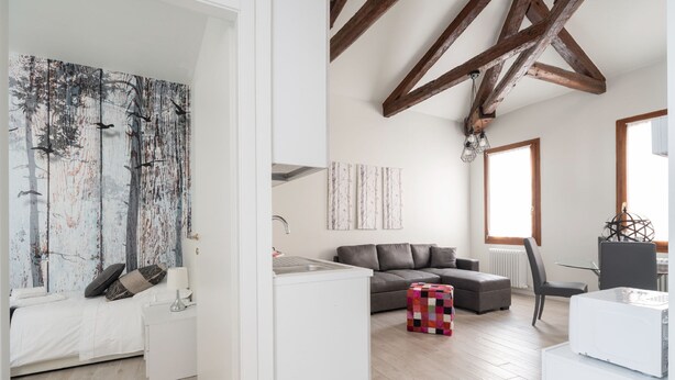 A modern apartment with a kitchen, living area, and a large window. - Apartments in San Marco with Canal View by Wonderful Italy (Venice)
