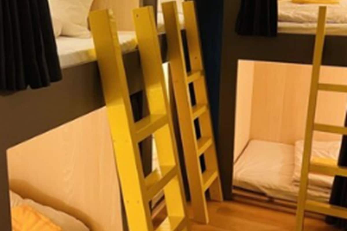 Una habitación pequeña con literas y un sofá pequeño.