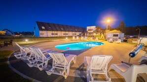 A swimming pool with lounge chairs and a building in the background. - Apartamenty Magnolia (Wicko)