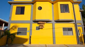 A yellow building with a sign reading "Khal Kob's Estate." - The Great Escape in Belize's Best Tourist Destinations!! (Placencia)