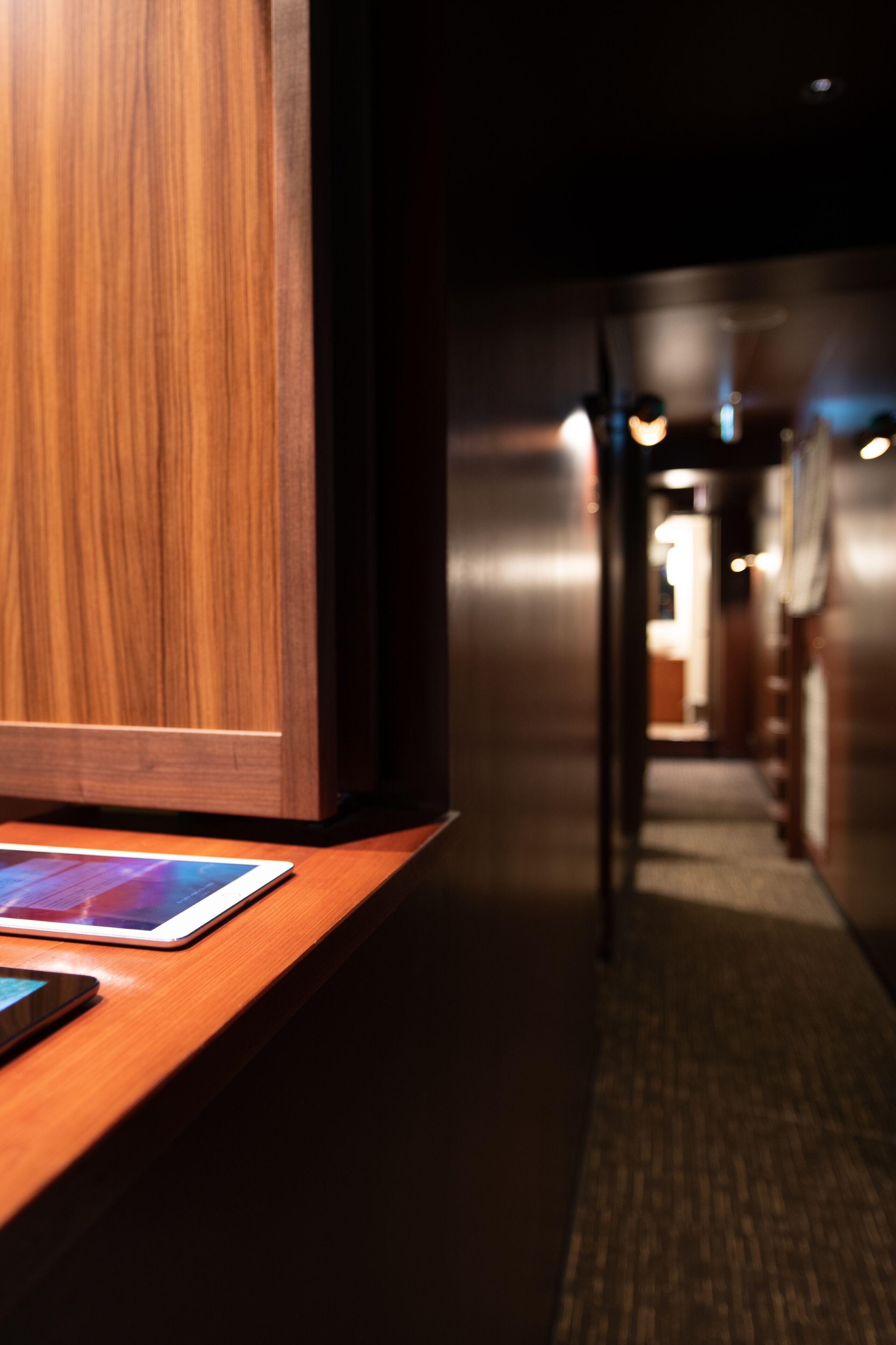 A wooden reception desk with a tablet and a smartphone.