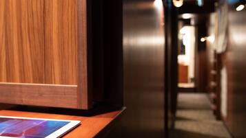 A wooden reception desk with a tablet and a smartphone.