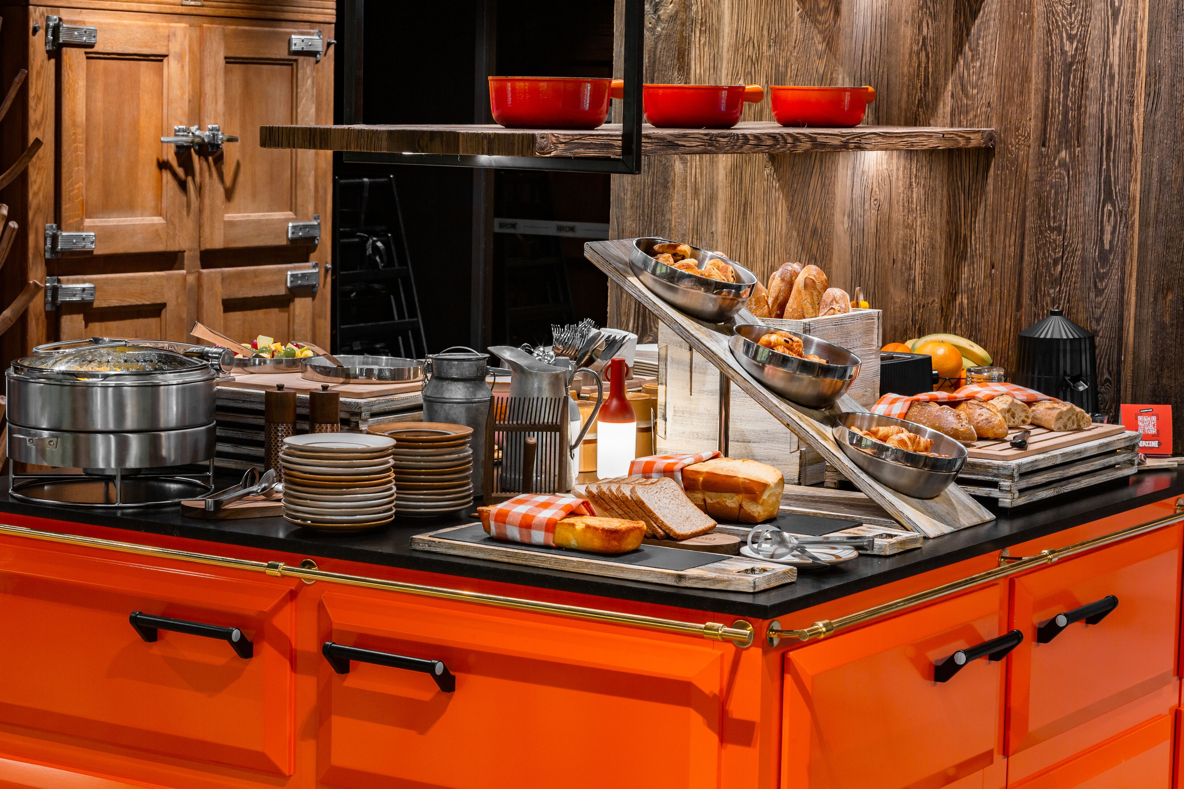 A buffet setup with various food items, cooking utensils, and serving dishes.