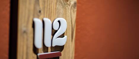 A wooden door with the number 112.