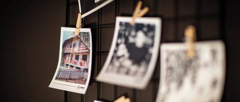 Una pared con varias fotografías sujetas con pinzas de madera.