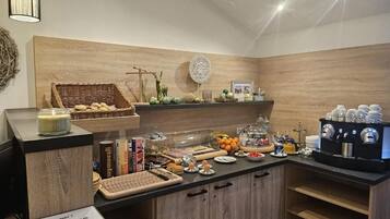 Een ontbijtbuffet met diverse etenswaren, een koffiehoek en decoratieve wandelementen.