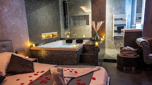 A modern bathroom with a large bathtub, a shower, and a mirror. - Suite Romantique (Narbonne)