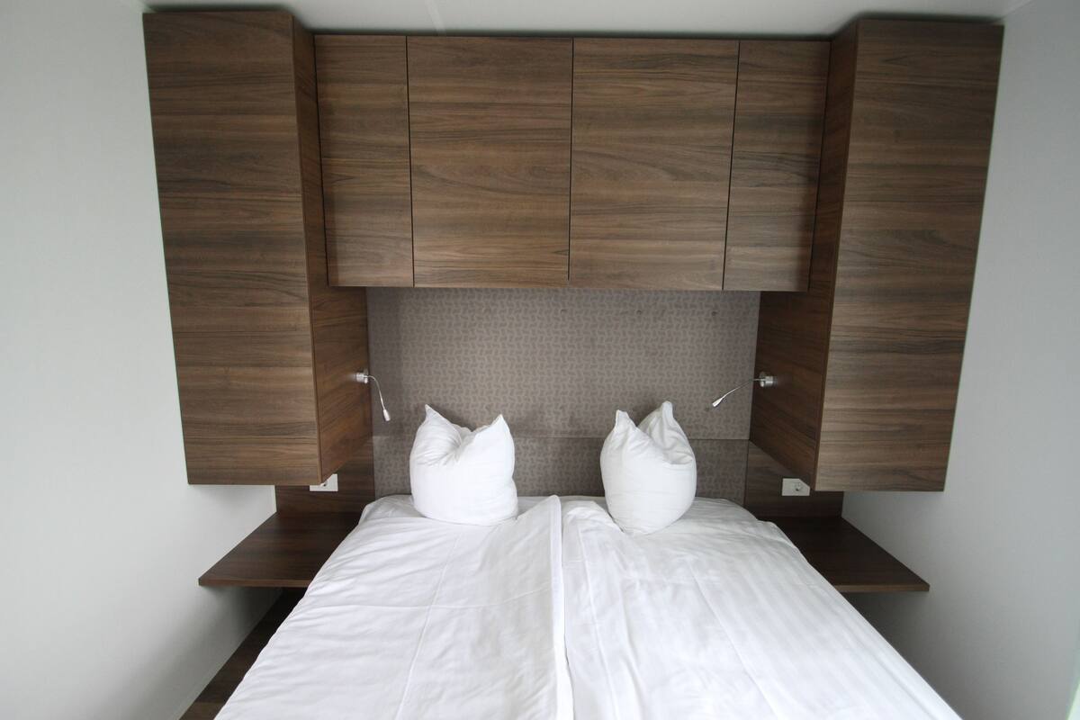 Un dormitorio con una cama, cabecero de madera y dos almohadas.