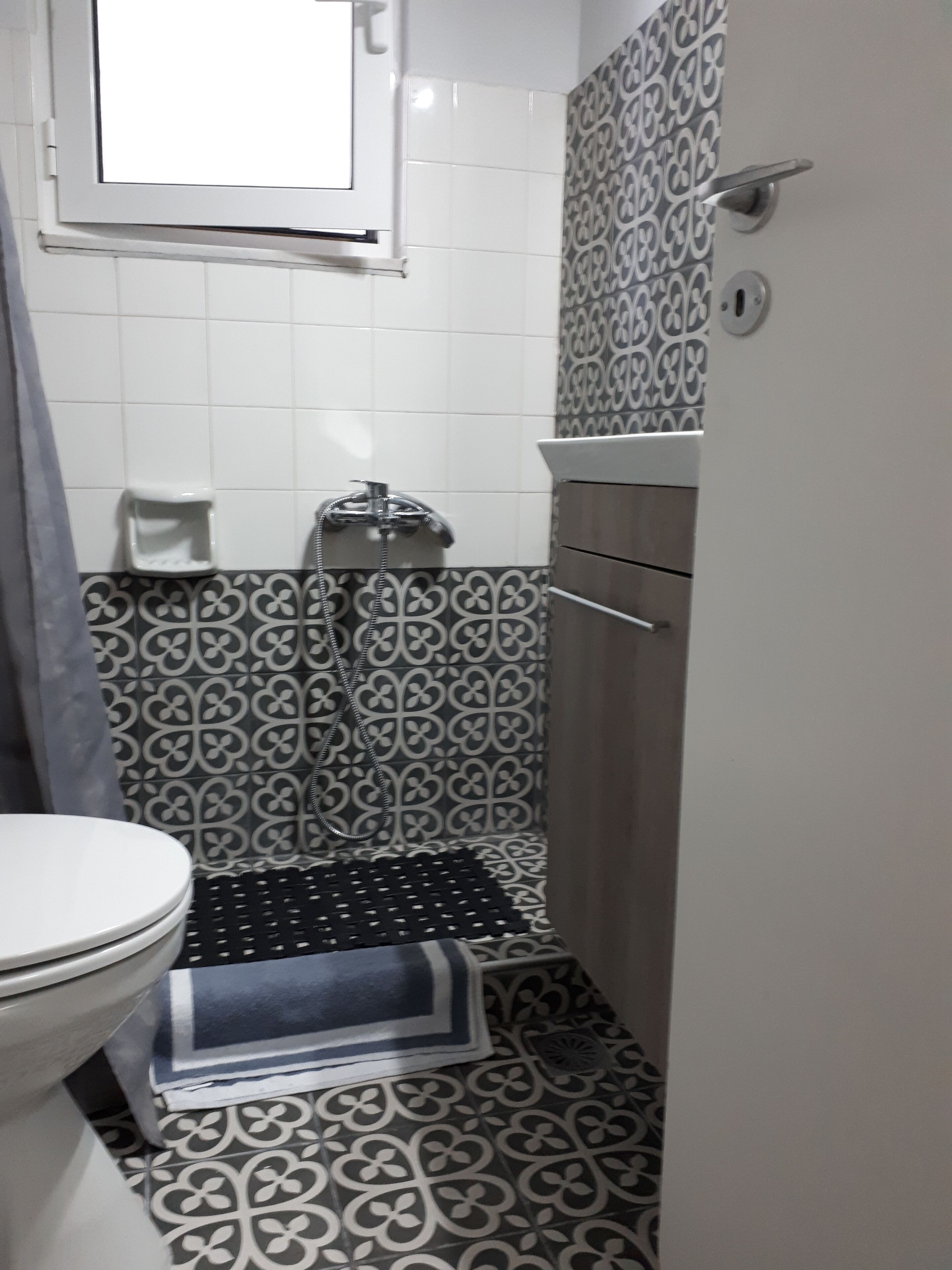 A bathroom with a toilet, a shower, and a sink.