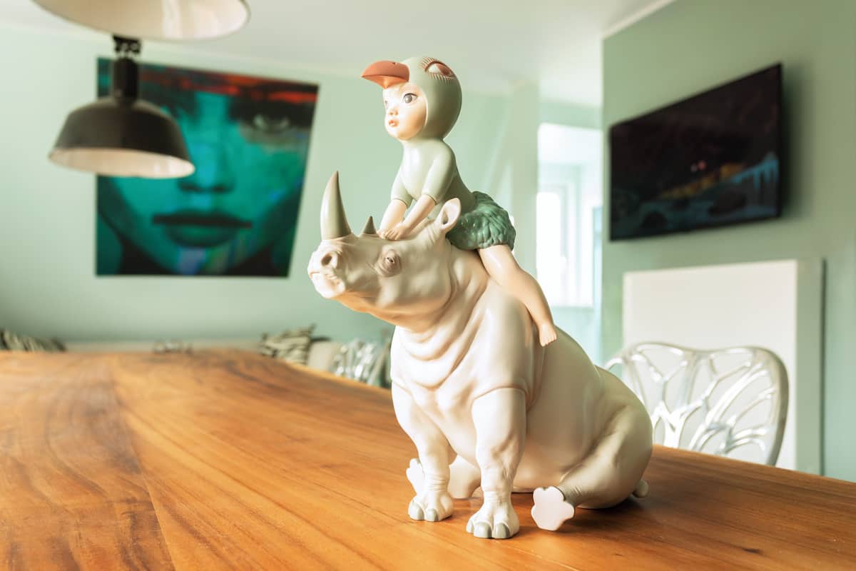 A dining table with a figurine of a child on a rhinoceros.
