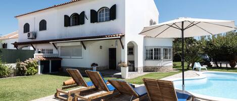 Utomhuspool, parasoller och solstolar