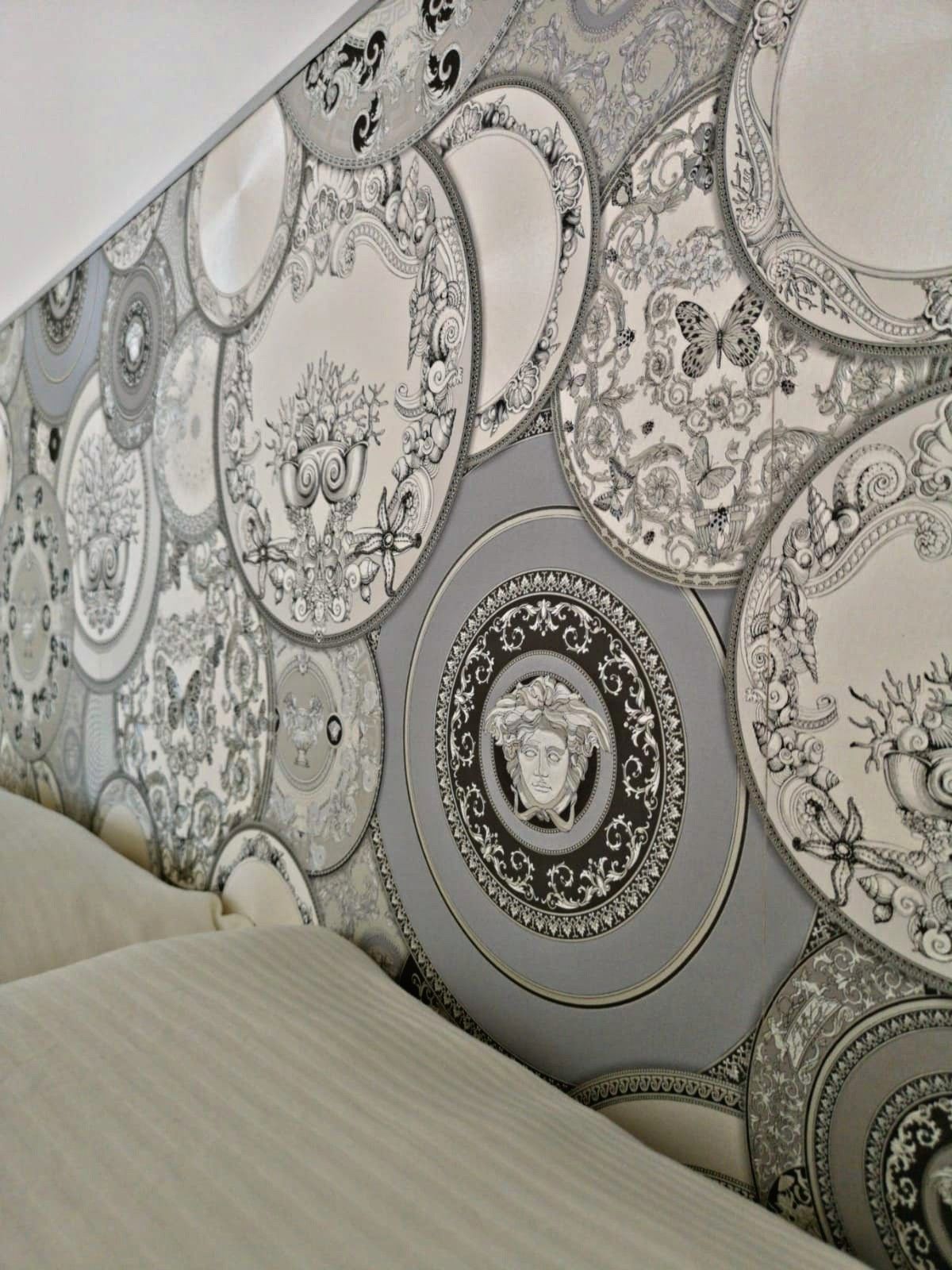 Una pared con papel tapiz estampado que presenta diseños circulares con motivos florales y ornamentales.