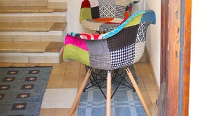 Un coin avec un fauteuil, une bibliothèque et un escalier.