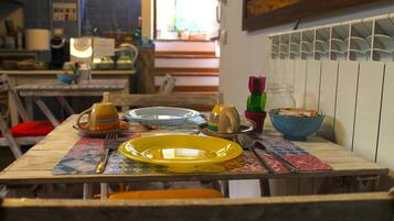 Una mesa de comedor con un plato amarillo, un tenedor y un cuchillo.