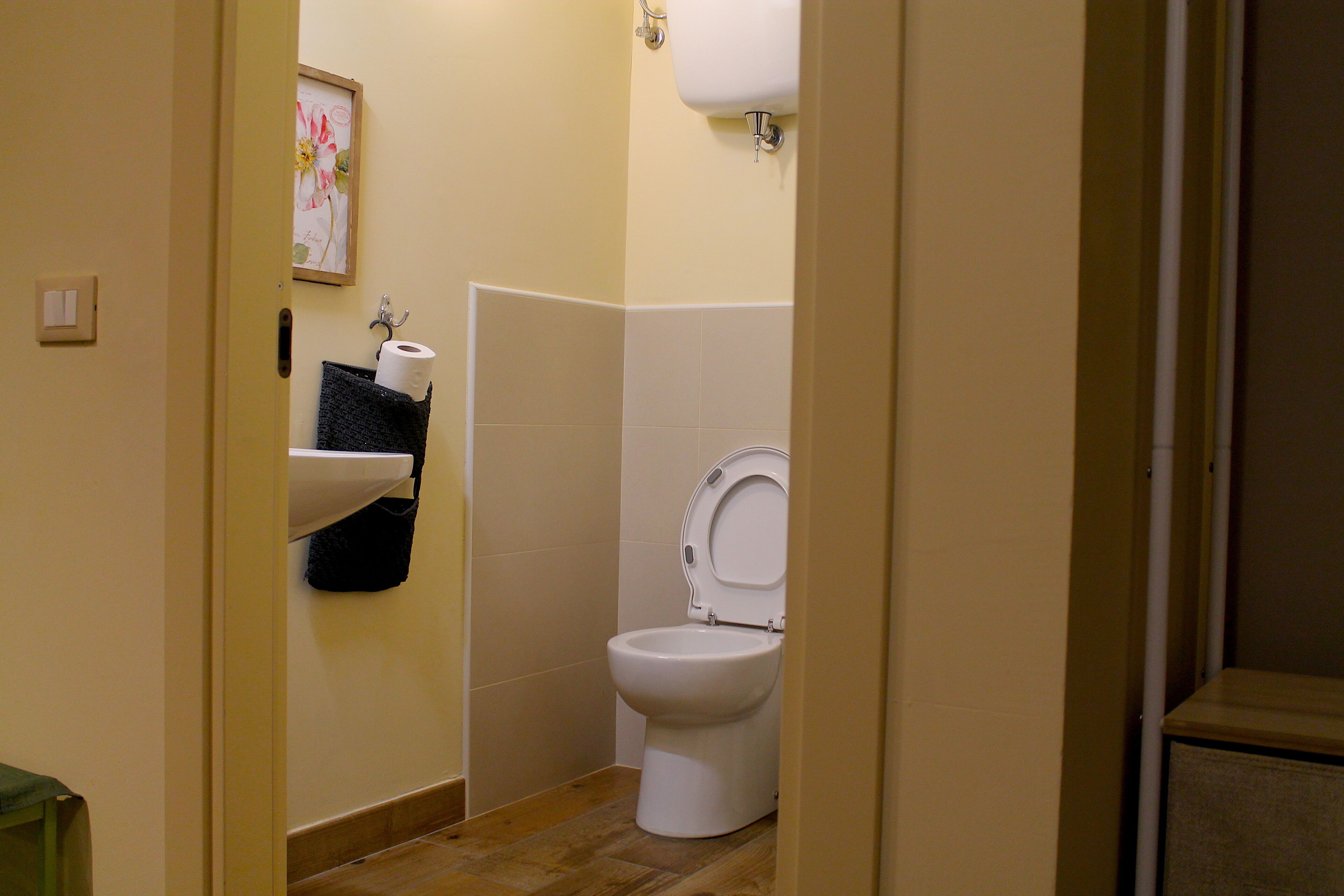Un baño pequeño con inodoro, lavamanos y toallero.