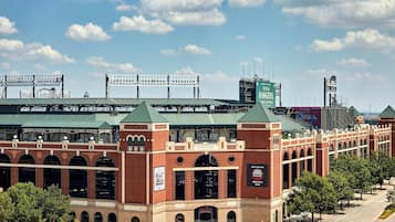 A stadium with a green roof, brick architecture, and multiple advertising banners.