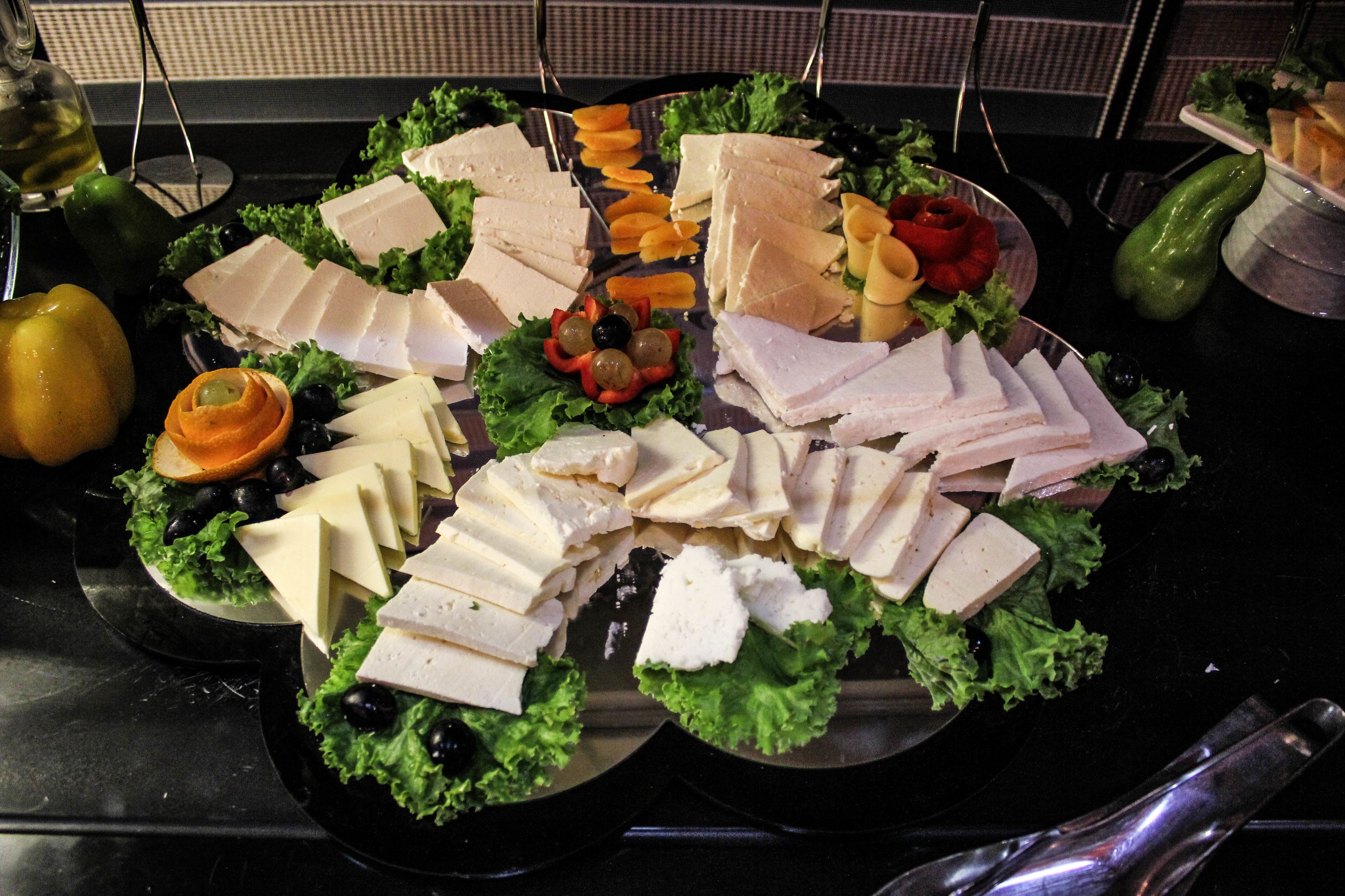 A platter of assorted cheeses and meats on a table.