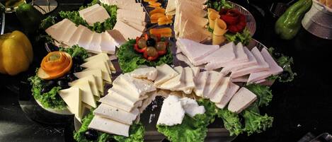 A platter of assorted cheeses and meats on a table.