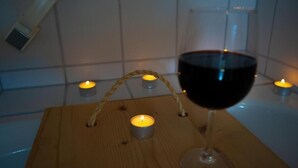 A wooden table with a wine glass and candles. - NATURION Hotel Hinterzarten (Hinterzarten)