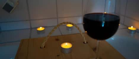 A wooden table with a wine glass and candles.