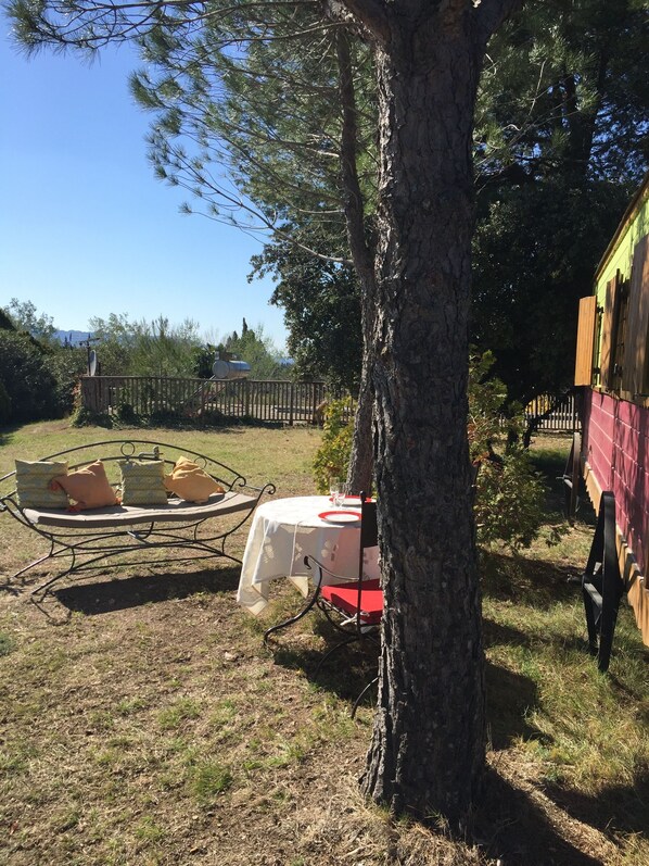 A picnic setup with a table, chairs, and a bench under a tree. - Trailer LA BUTTE BLANCHE (Plan-d'Orgon)