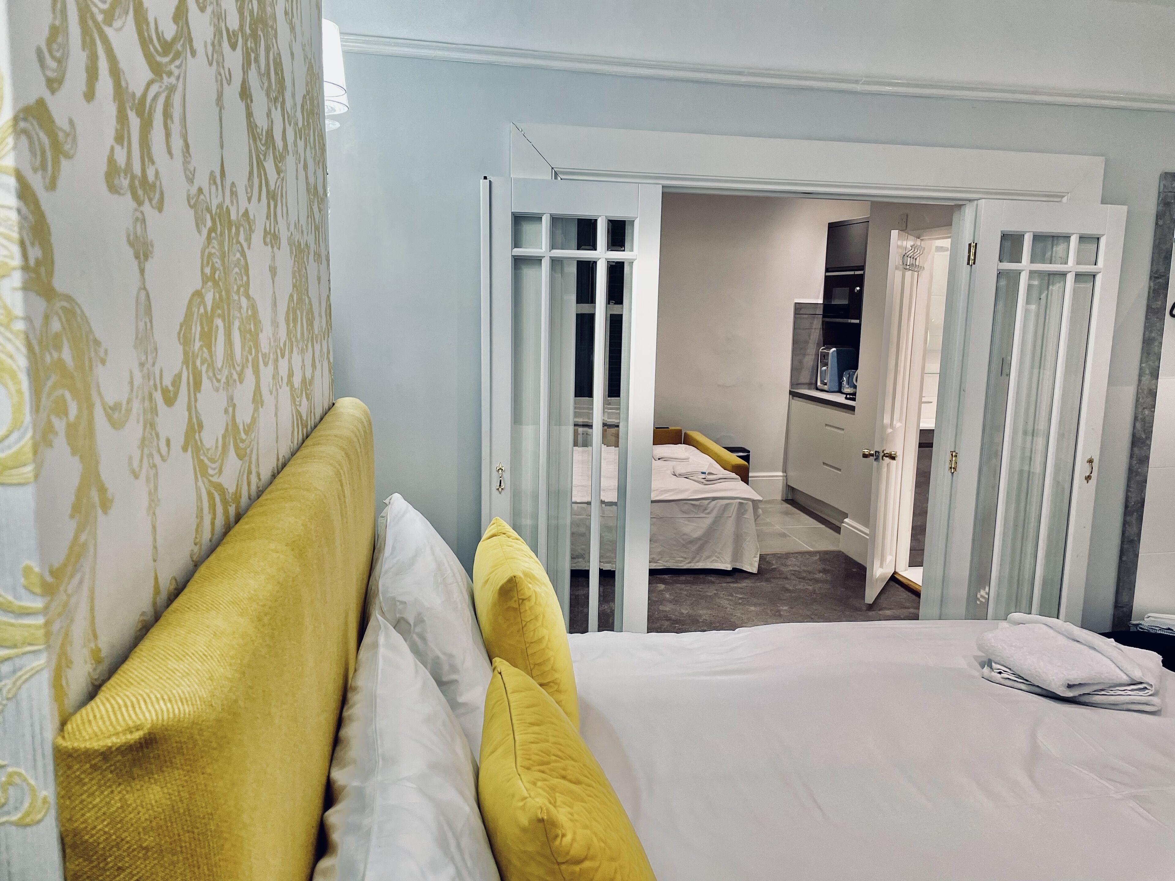 Hotellihuone, jossa on sänky, kylpyhuone ja pieni keittiönurkkaus.