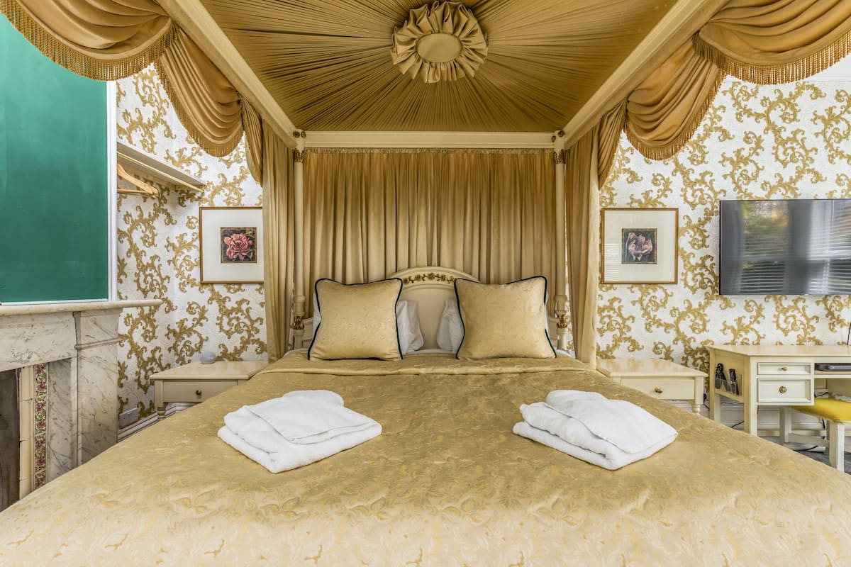A well-appointed bedroom with a large bed, a television, and a desk.
