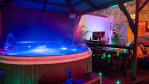 A hot tub area with wooden benches and a bar. - Ashbys (Portsmouth)