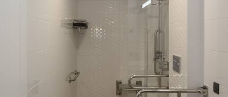 A modern bathroom with a glass shower enclosure, a white toilet, and a sink with a mirror.