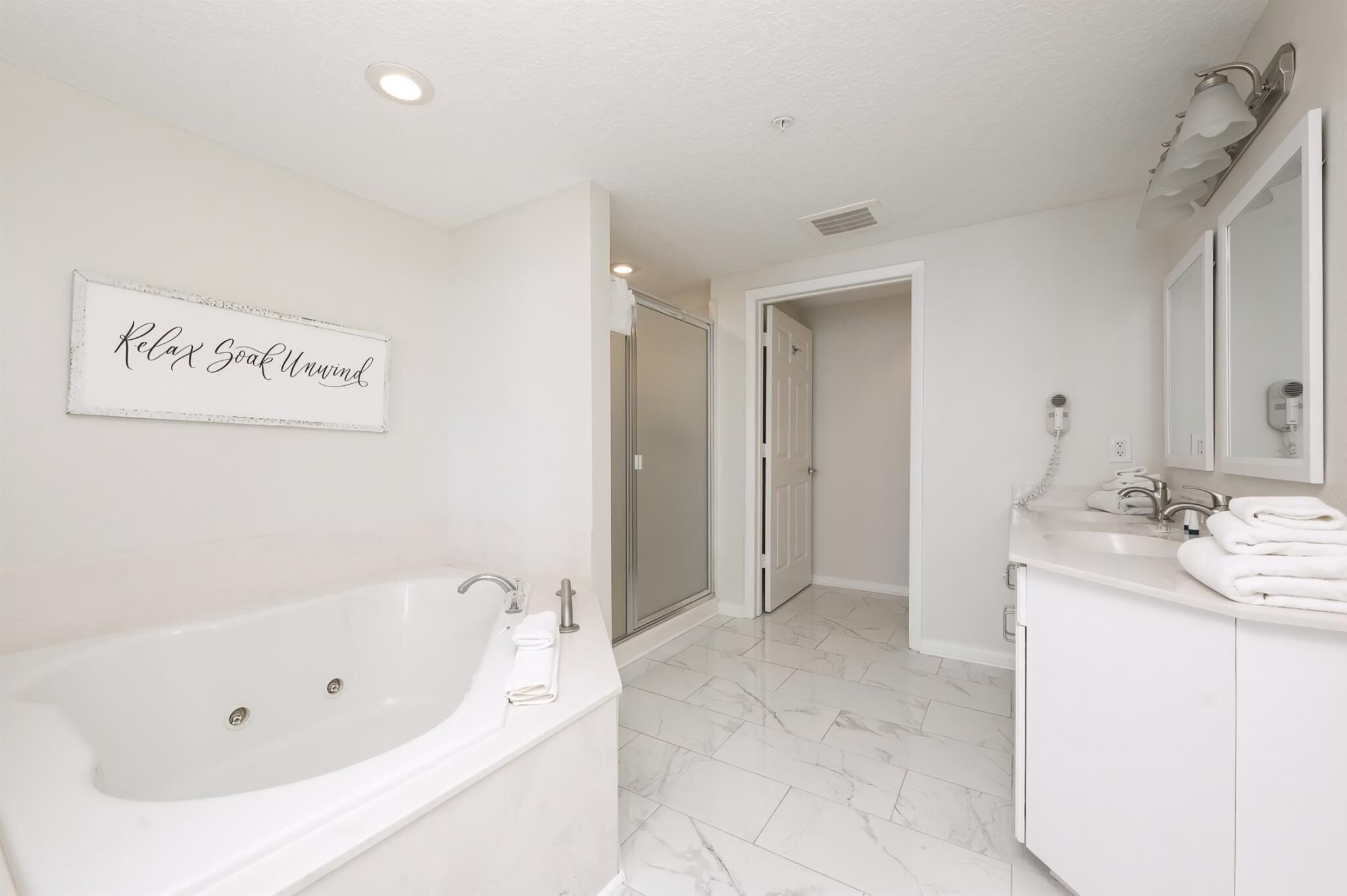 A modern bathroom with a bathtub, a shower, and a vanity with a mirror.