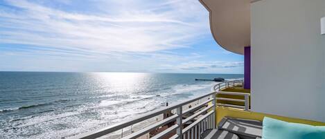 Un balcon avec vue sur la plage et l’océan.