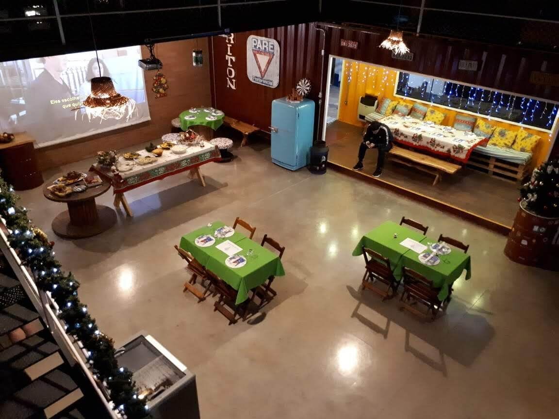 A dining area with tables set for meals, a projection screen displaying a presentation, and a Christmas tree in the corner.