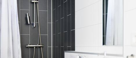 A modern bathroom with a shower, toilet, and sink.